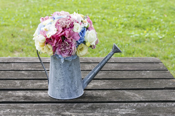 Bouquet of flowers in silver watering can