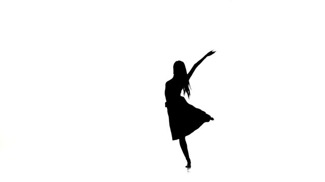 Slim woman dancer dancing contemporary dance, turns around, on white, silhouette, slow motion