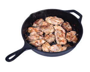 Chicken thighs and cast iron skillet on white background