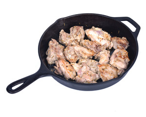 Chicken thighs and cast iron skillet on white background
