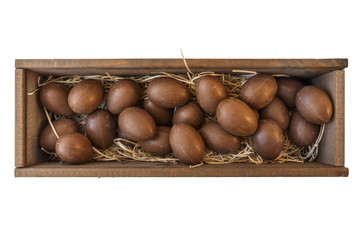 Chocolae Easter eggs in wooden crate with straw isolated