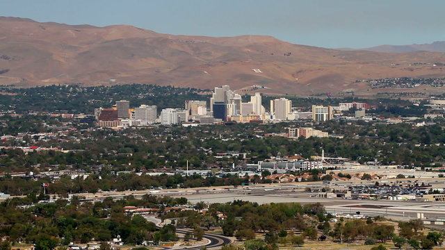 Traffic moves along Interstate 580 in Reno, Nevada, USA, with a view of the city skyline and highrise casinos in the background.