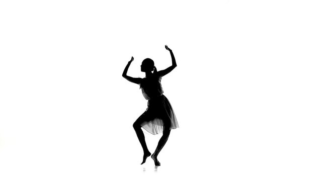 Slim girl with ponytail starts dance modern contemporary style on white, silhouette, slow motion