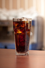 glass of cola with ice on the bar