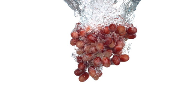 Grapes splashing into water, slow motion