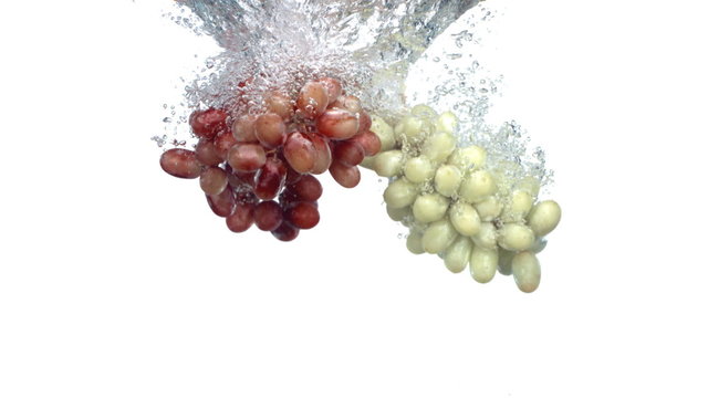 Grapes splashing into water, slow motion