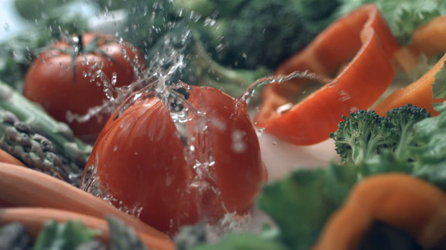 Tomato splashing into water, slow motion