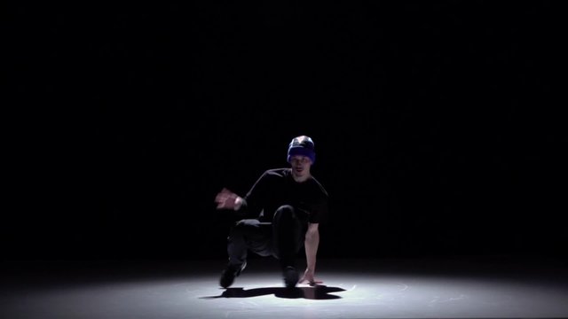 Modern breakdance man jumping dancing on black, shadow, slow motion