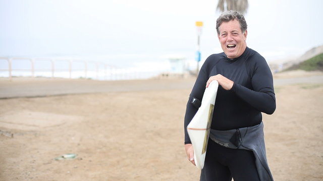 Middle aged man at beach with surf board