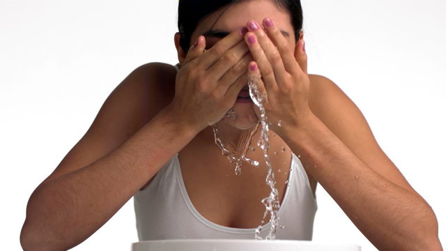 Young woman splashing water on face