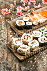 Sushi, maki, sashimi and sushi rolls. Spring flowers