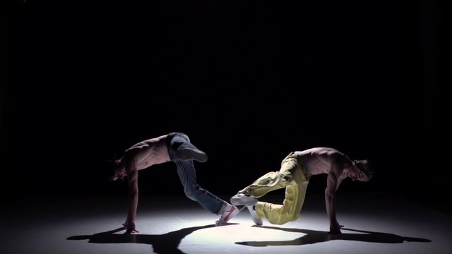 Two dancers performing and start dance breakdance on black, shadow, slow motion