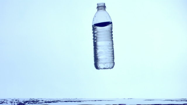 Water bottle falling and splashing, slow motion