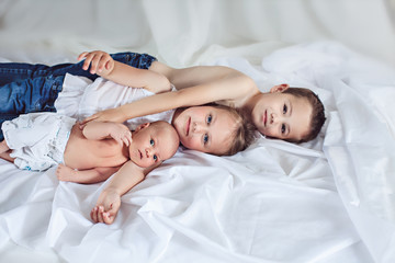 Obraz na płótnie Canvas Newborn baby with brother and sister lying