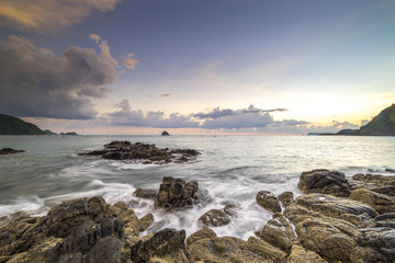 Fototapeta na wymiar Natural rock with strong water wave and sunrise background at Belanak Beach, Lombok, Indonesia