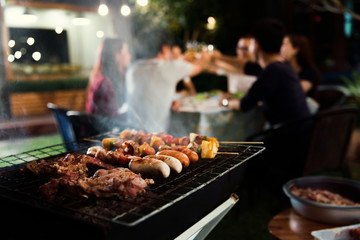 Dinner party, barbecue and roast pork at night - obrazy, fototapety, plakaty
