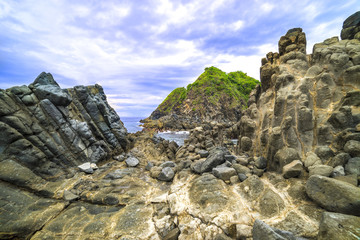 Natural rock with strong water wave and cloudy sunset background at Pantai Semeti Lombok, Indonesia.