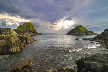 Fototapeta na wymiar Natural rock with strong water wave and cloudy sunset background at Pantai Semeti Lombok, Indonesia.