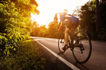 Female cyclist cycling am The path in the woods and mountains