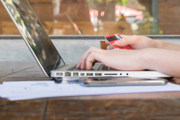 Businessman entering information from a credit card using laptop