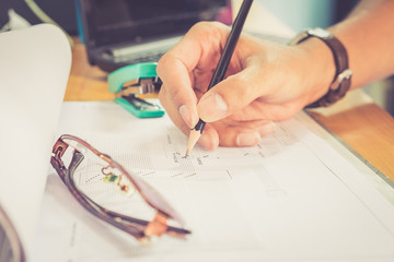 Engineer holding a pencil to check diagram for fiber optic core