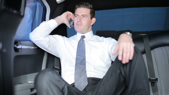 Businessman in limo talking on cell phone