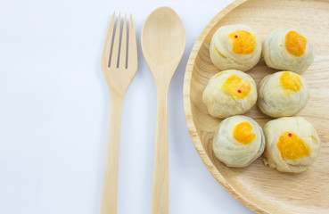 Chinese Pastry Mung Bean or Mooncake with Egg Yolk on wooden dish and spoon fork