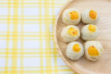 Chinese Pastry Mung Bean or Mooncake with Egg Yolk on wooden dish striped cloth