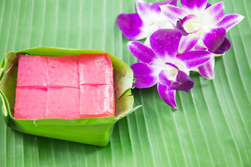 Kind of Thai sweetmeat, Multi Layer Sweet Cake (Kanom Chan) on banana leaf with orchid flower