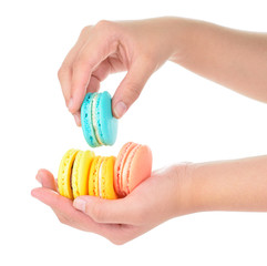 hand holding colorful macarons on white background