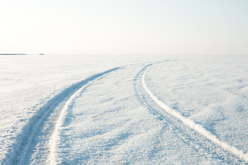 Fototapeta na wymiar snow desert and the tracks of the car in the snow