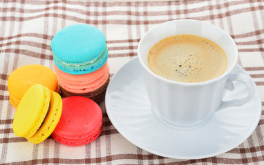 close up of colorful macarons and cup of coffee