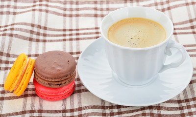 close up of colorful macarons and cup of coffee
