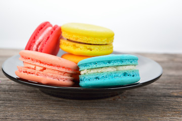 colorful macarons on wooden texture