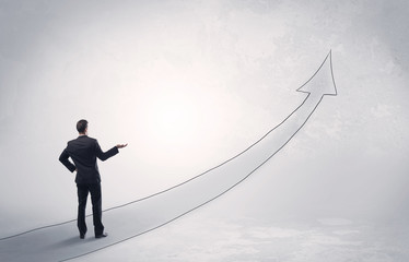 Business man standing on drawn arrow