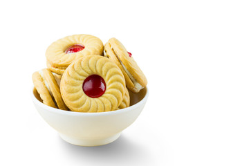 Sandwich cookies with cream and strawberry flavoured jam on whit