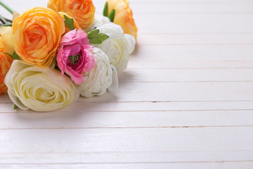 Border from  pink, white and yellow flowers  on white wooden bac