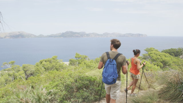 Hiking couple hikers walking in nature on Mallorca, Europe. Young adults walking in beautiful landscape on the coast of Mallorca, Balearic Islands, Spain. Famous European summer destination. RED EPIC.