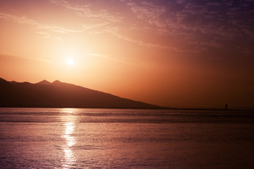 Sun, evening sky and sea water. Red toned