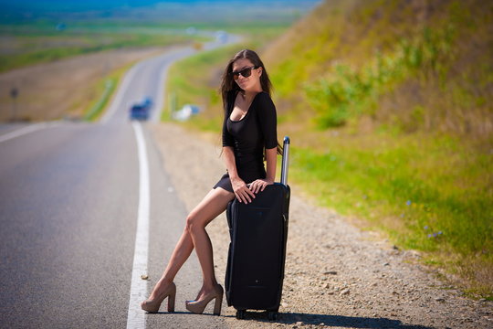 brunette woman road suitcase
