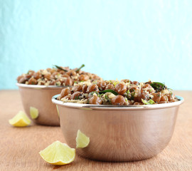 Indian food brown chickpea curry, a healthy vegetarian, traditional and popular side dish, in steel bowls.