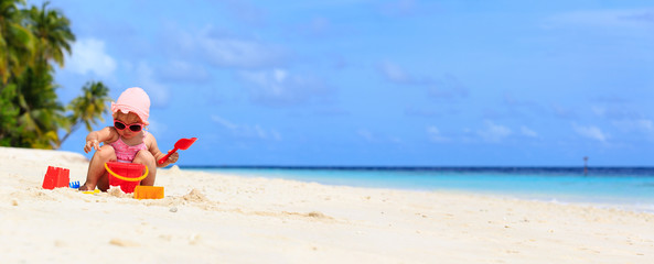 cute little girl play with sand on the beach