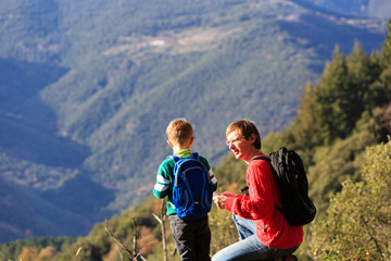 Obraz premium father and son travel in mountains looking at map