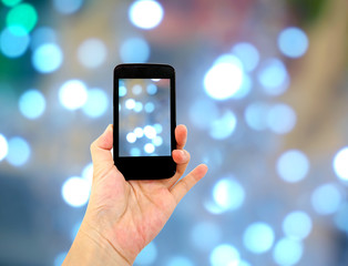 woman hand hold and touch smart phone,cell phone,mobile over bokeh background