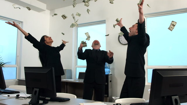 Businesspeople celebrate as money falls