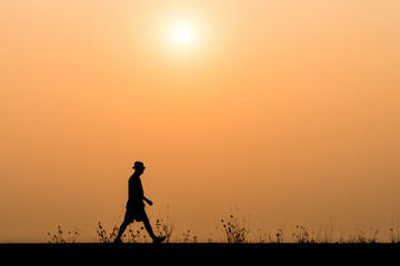 Fototapeta premium silhouette man walking on the sunset background