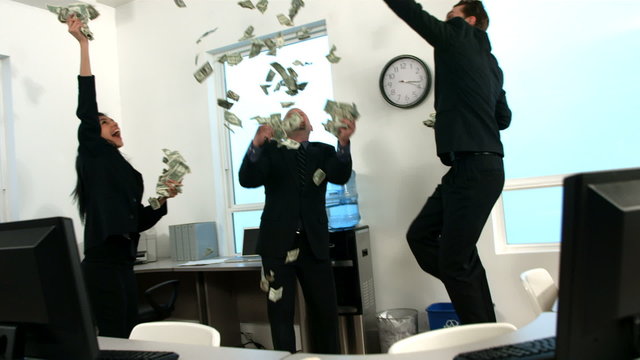 Businesspeople in office throwing money