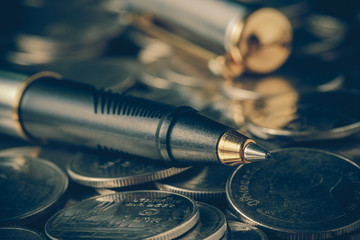 Naklejka premium money concept coins and pen with filter effect retro vintage sty