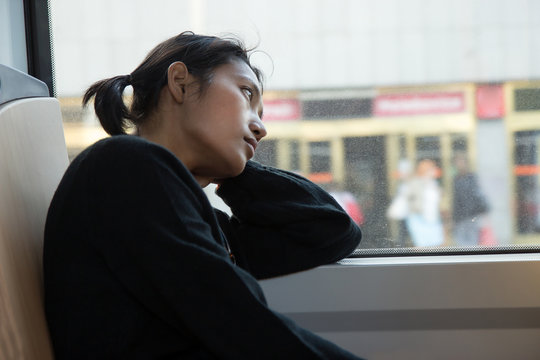 melancholic woman looks out the window of tram
