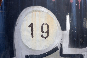  Number 19 on old painted and rusted metal panel